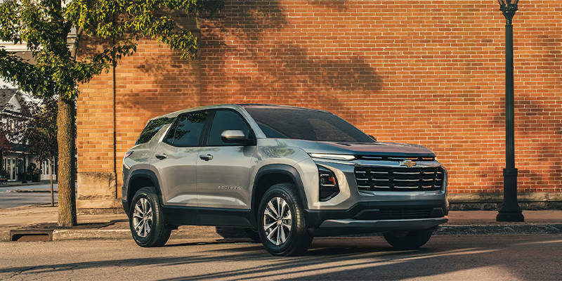 A silver Chevrolet Equinox parked in a city street.