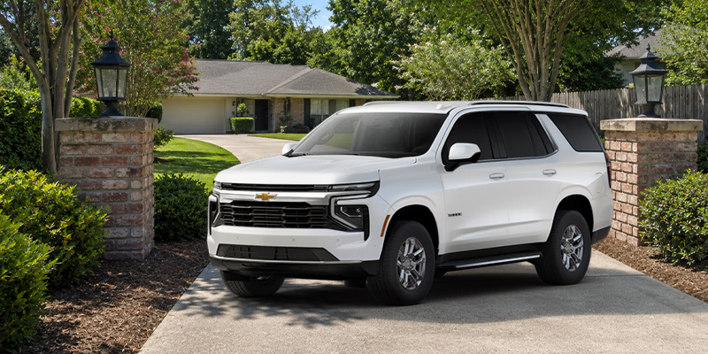 A white Chevrolet Tahoe parked in a driveway.