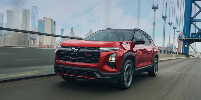 A red Chevrolet Equinox (specifically an RS trim) driving across a bridge.